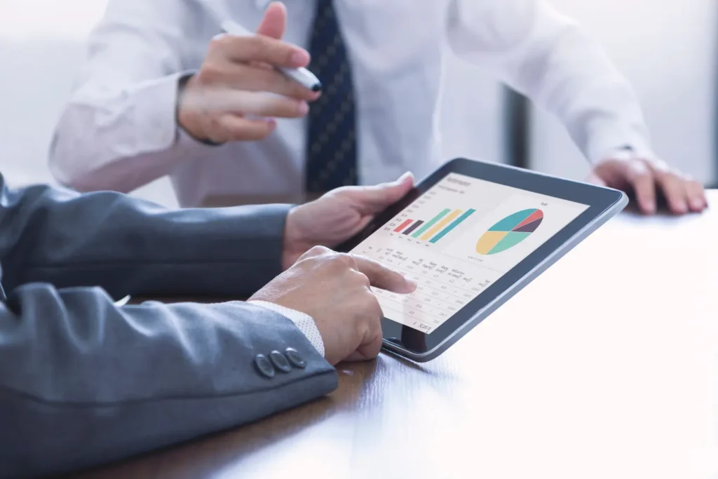 a business man going over performance reports on a tablet - Digitech
