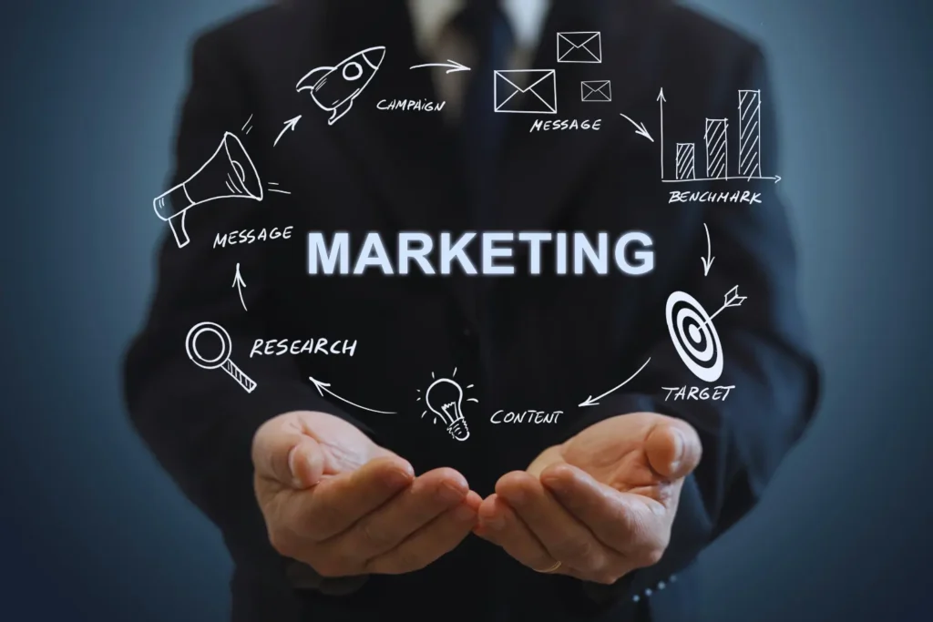 a business man holding out his hands with marketing icons floating around them - digitech