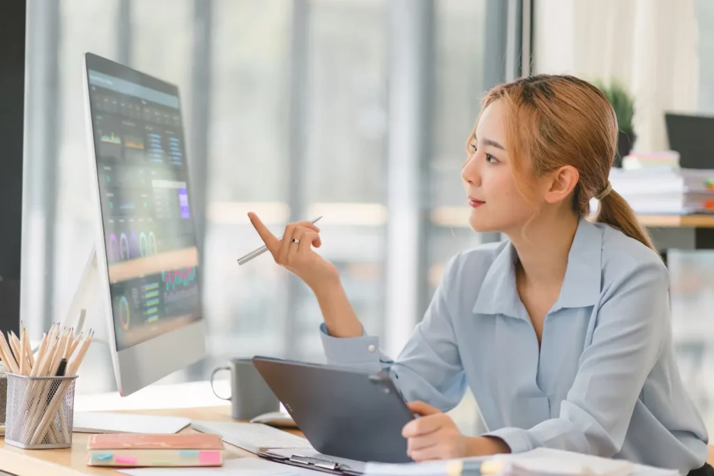 a woman pointing her finger at marketing data on her screen - Digitech
